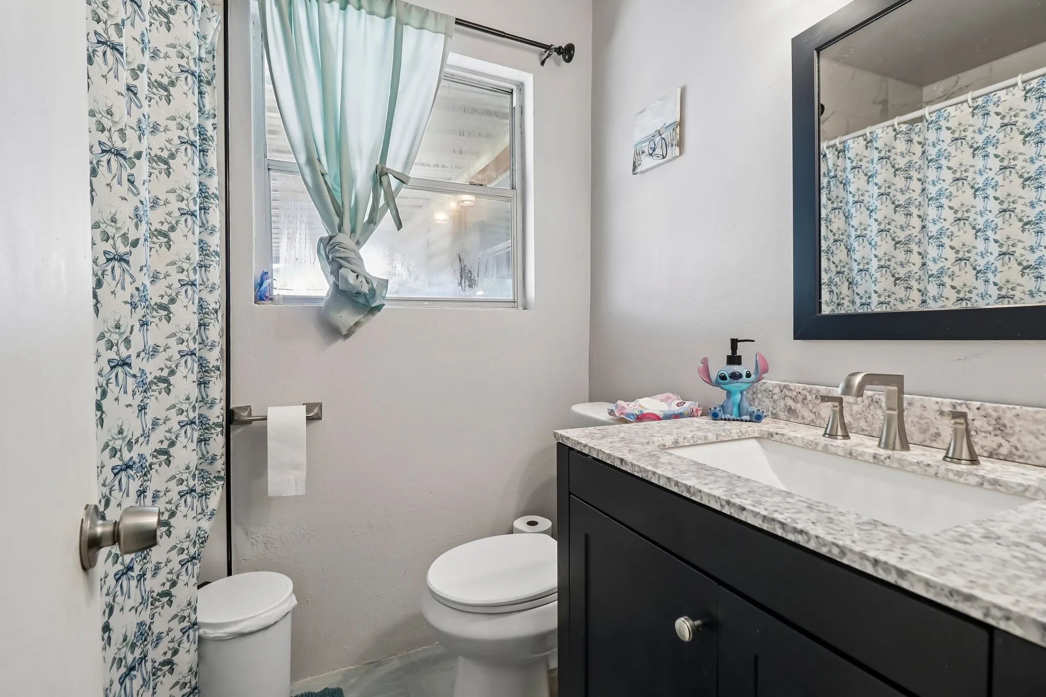 Vanity with a light-colored countertop, undermount sink, and brushed nickel faucet
