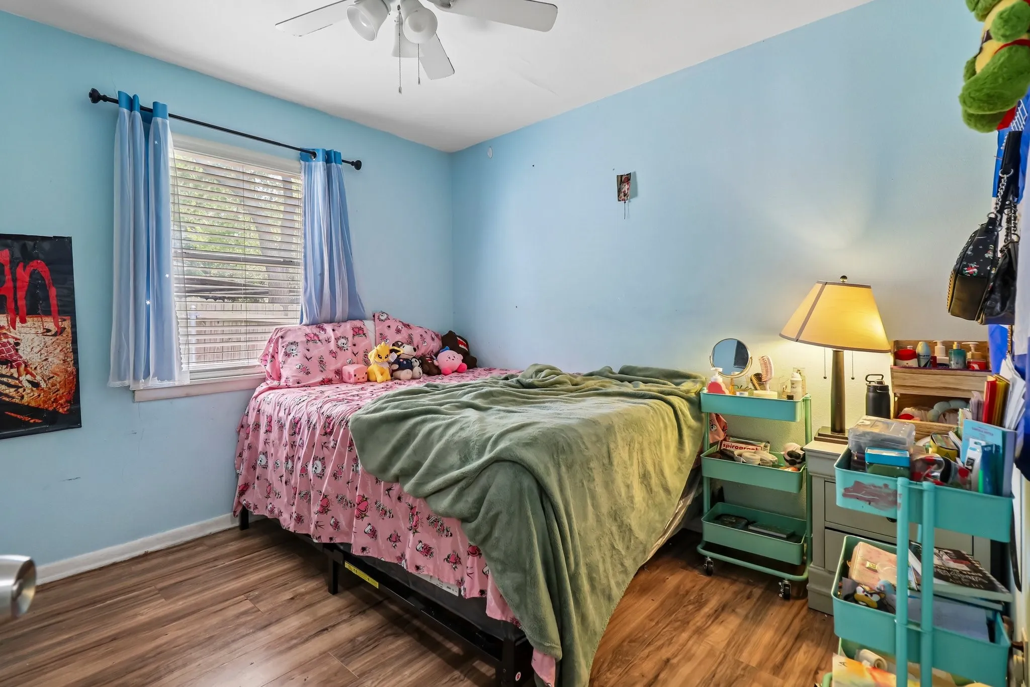 Wood-finish flooring with a white ceiling fan and light fixture