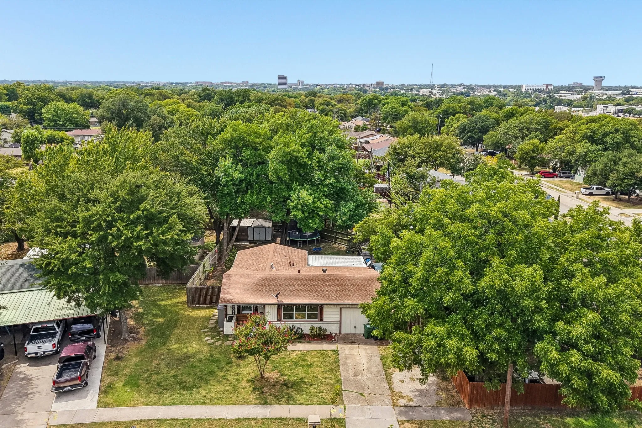 Residential property with a brown shingle roof, concrete driveway, and concrete walkway