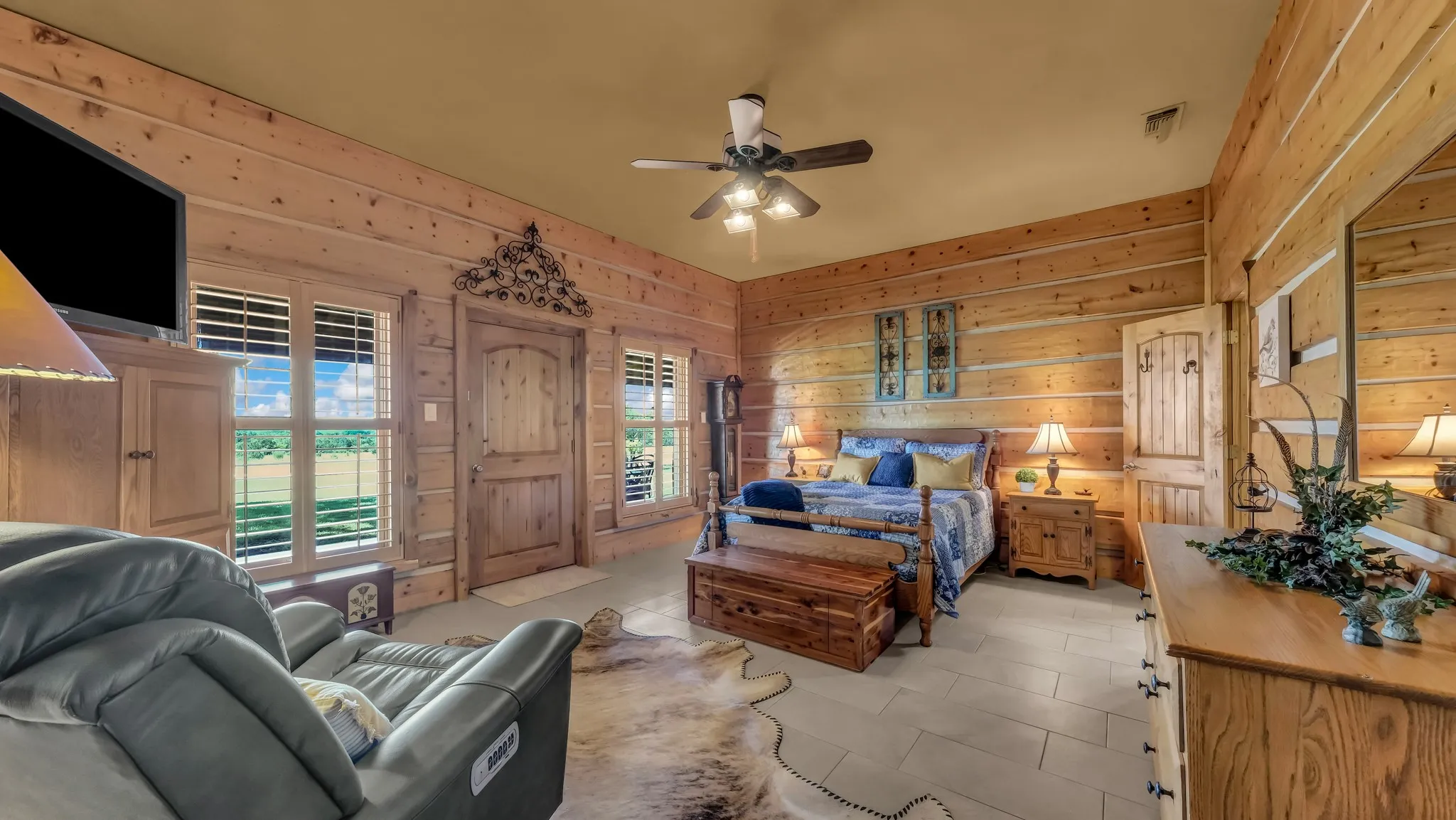 Large guest bedroom with a door to the porch and windows with a view.