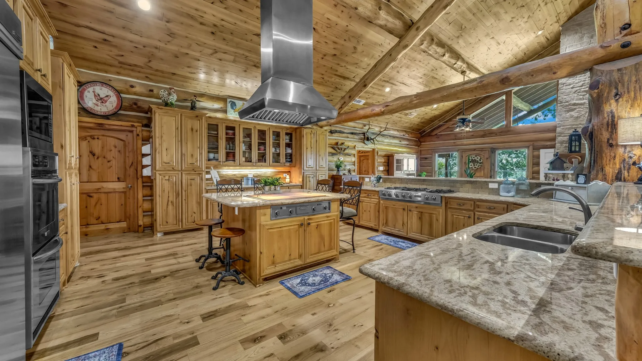Island bar with surrounding seating area. Notice this awesome vent a hood with lights over the fabulous grill.