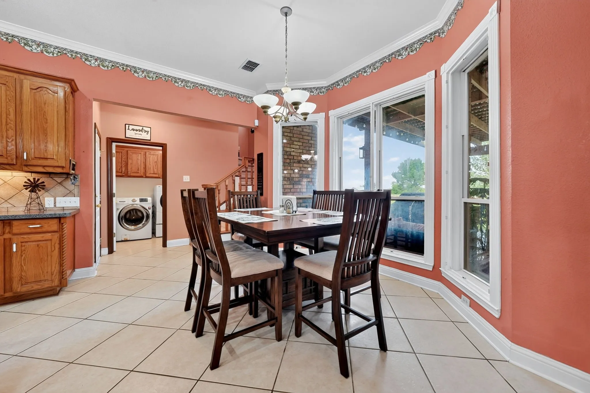 Dining area featuring a bay window, tile flooring, and a decorative chandelier