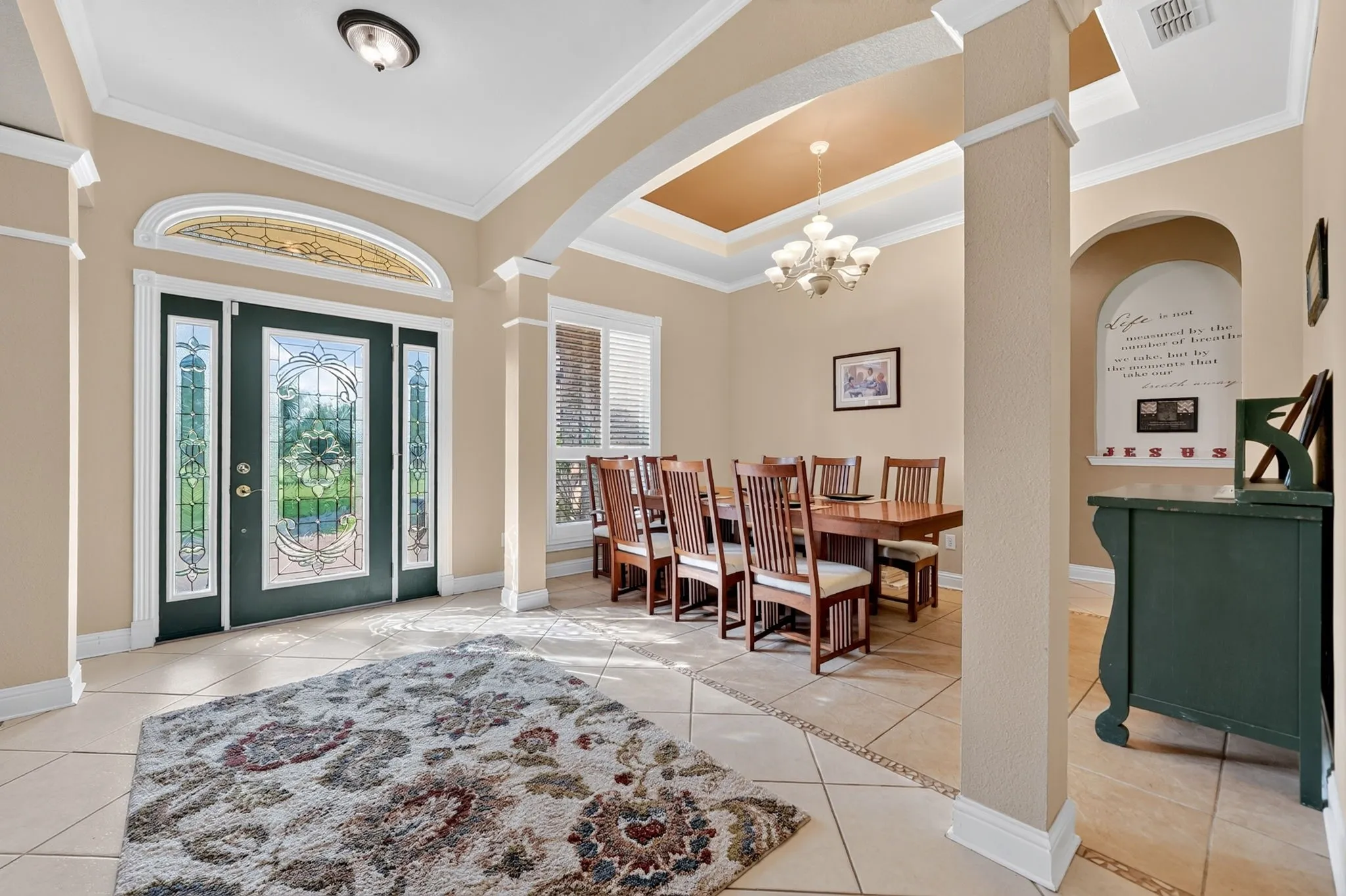 Grand entryway featuring a decorative glass main door with sidelights and an arched transom window