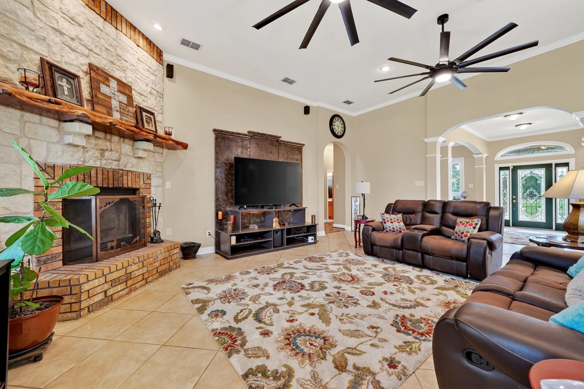 Living area featuring a floor-to-ceiling stone and brick fireplace with a wood mantle