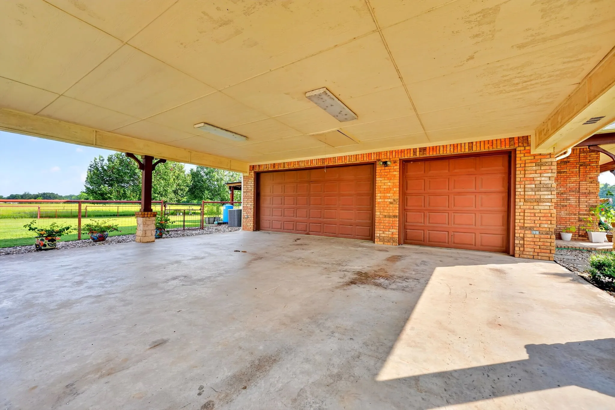 Expansive covered concrete carport offering direct access to the two-car garage