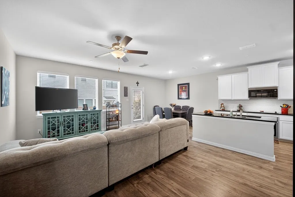 Open-concept living area featuring wood-finish flooring, recessed lighting, and a ceiling fan