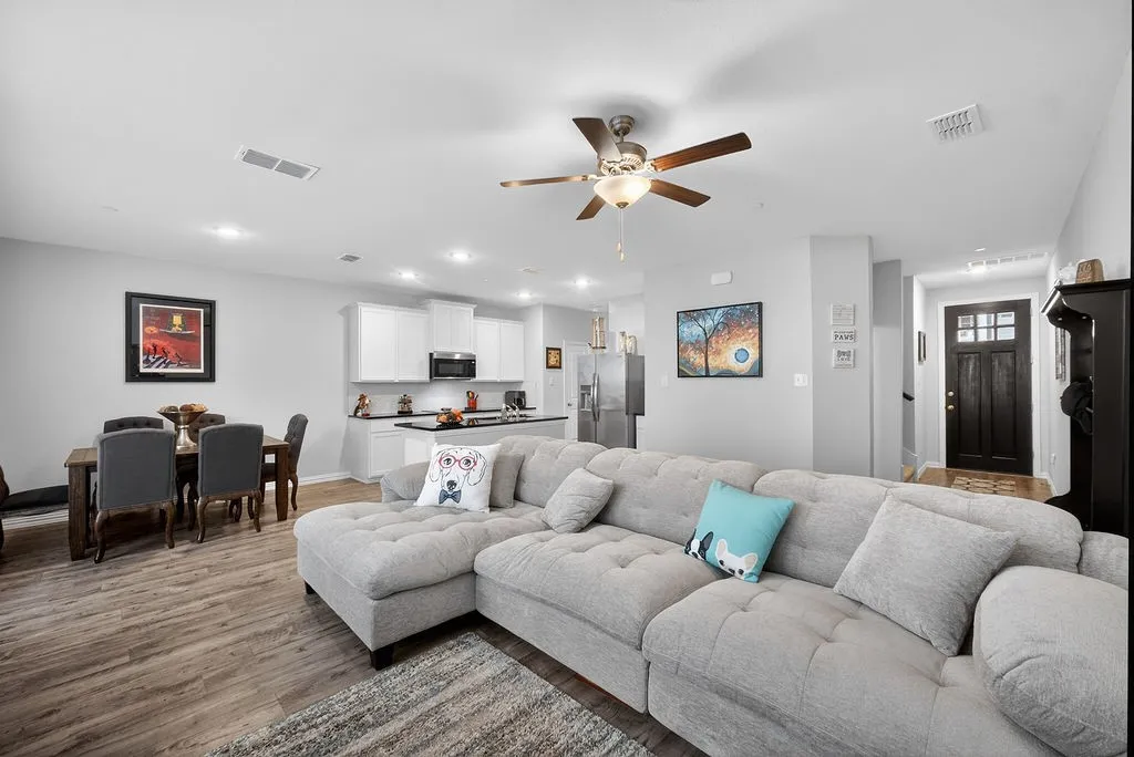 Open-concept living space featuring wood-finish flooring, recessed lighting, and a ceiling fan