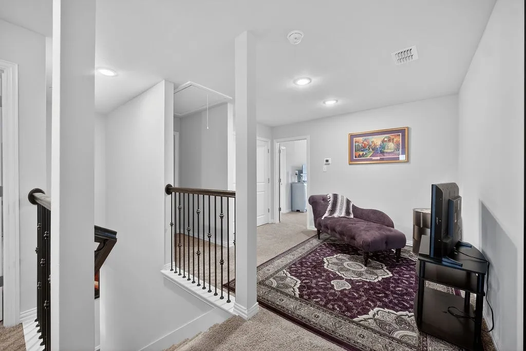 Landing area featuring recessed lighting, light gray wall paint, and a built-in wrought iron and wood railing