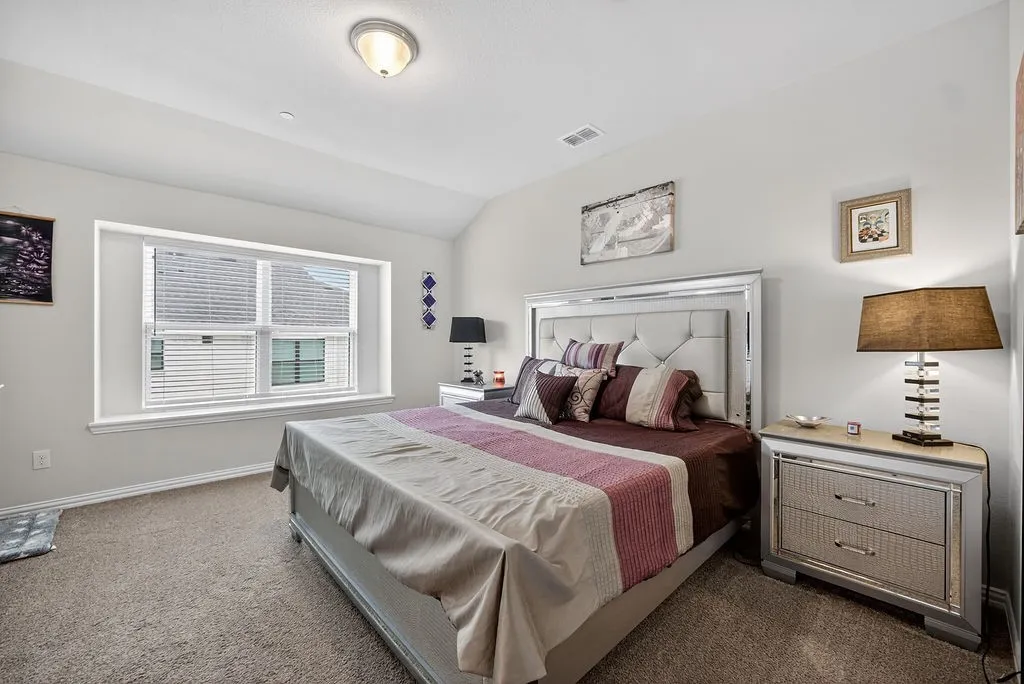 Carpeted room with a vaulted ceiling and recessed lighting