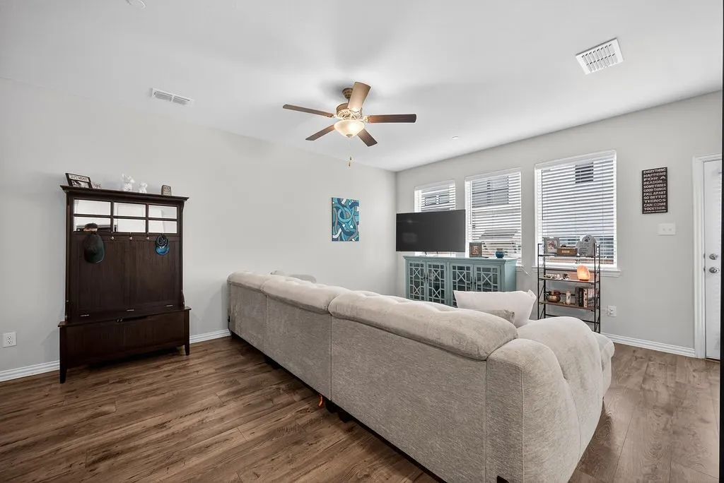 Open-concept living area featuring wood-finish flooring, light gray wall tones, and white trim