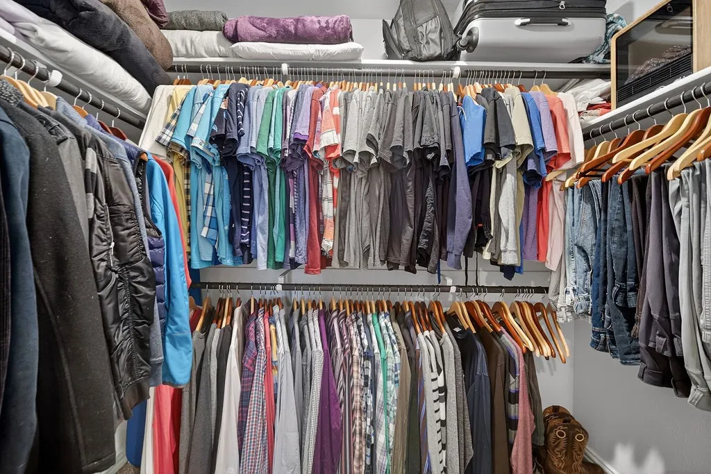 Custom closet system featuring multiple hanging rods, integrated shelving, and white walls