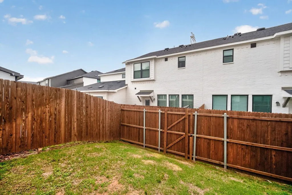 Private backyard featuring a stained wood privacy fence with a pedestrian gate
