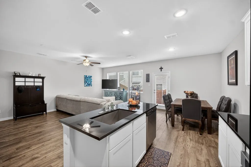 Open-concept living space featuring wood-finish flooring, recessed lighting, and a ceiling fan