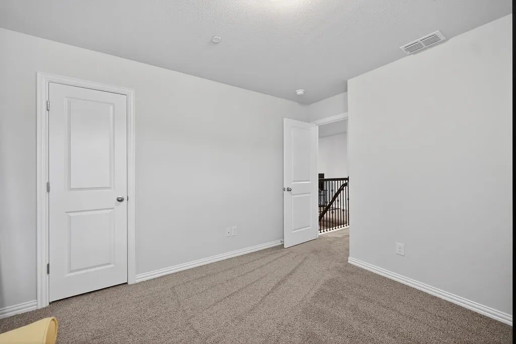 Carpeted room with light gray walls, white trim, and white paneled doors