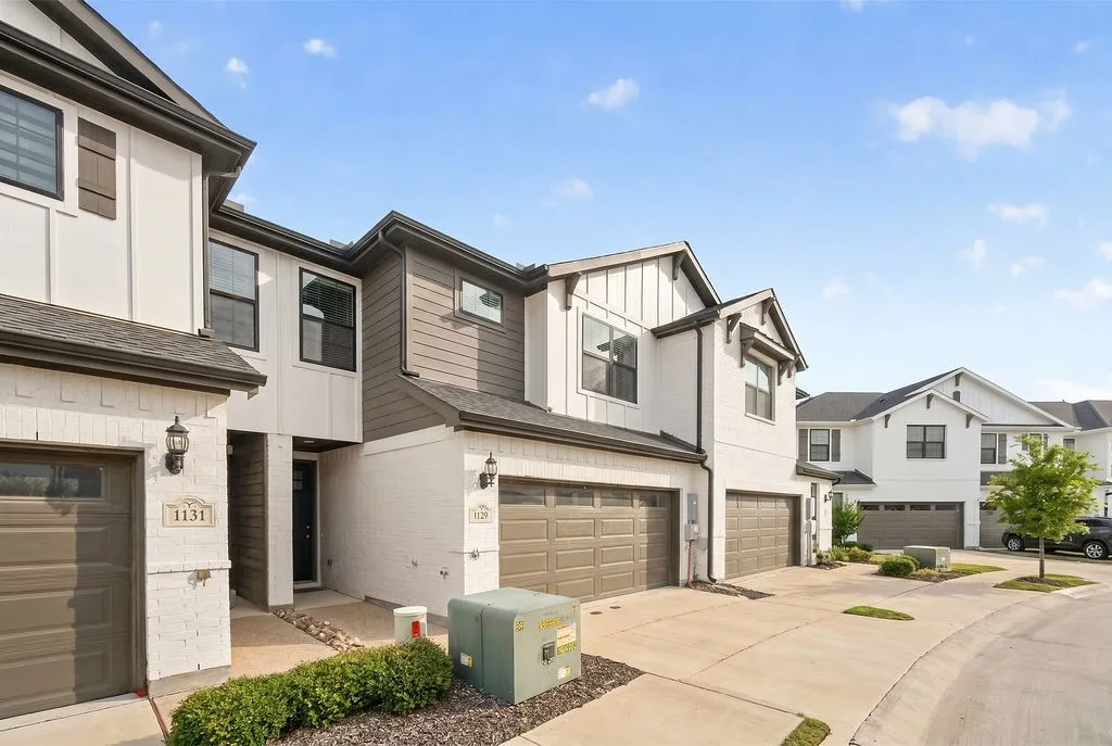 Modern townhome exterior featuring white brick and dark gray siding