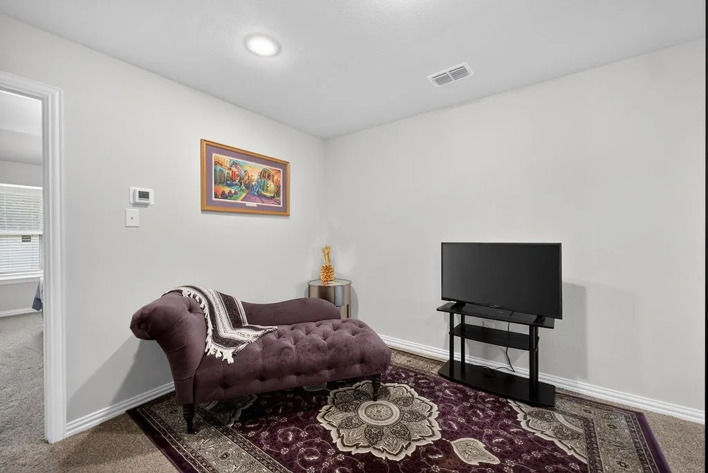Spacious room featuring neutral painted walls, recessed lighting, and carpet flooring