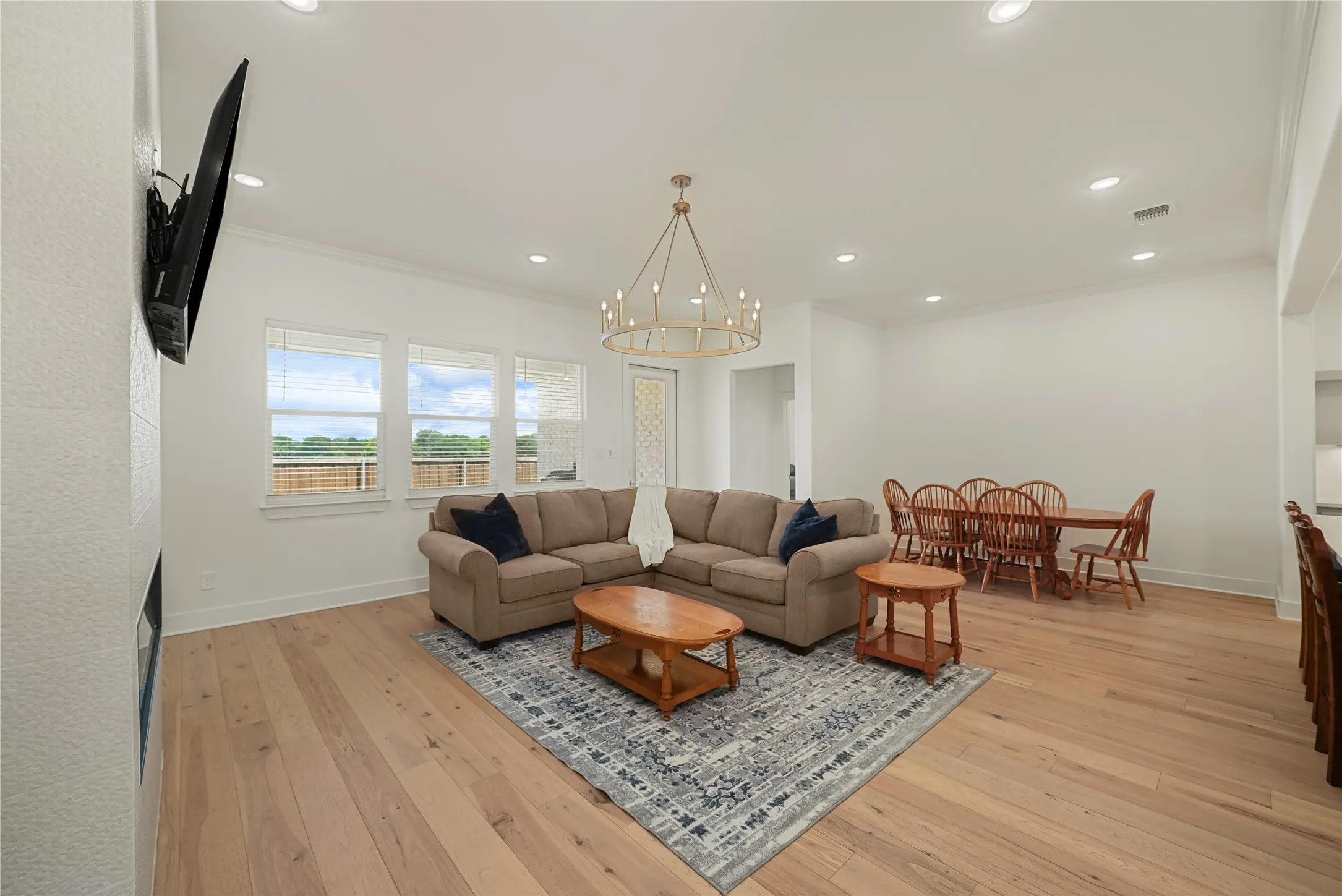 Spacious interior featuring light wood-finish flooring, recessed lighting, and a modern chandelier