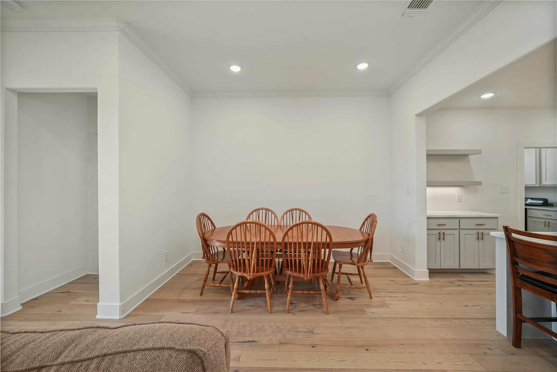 Open dining area featuring wood-finish flooring and recessed lighting
