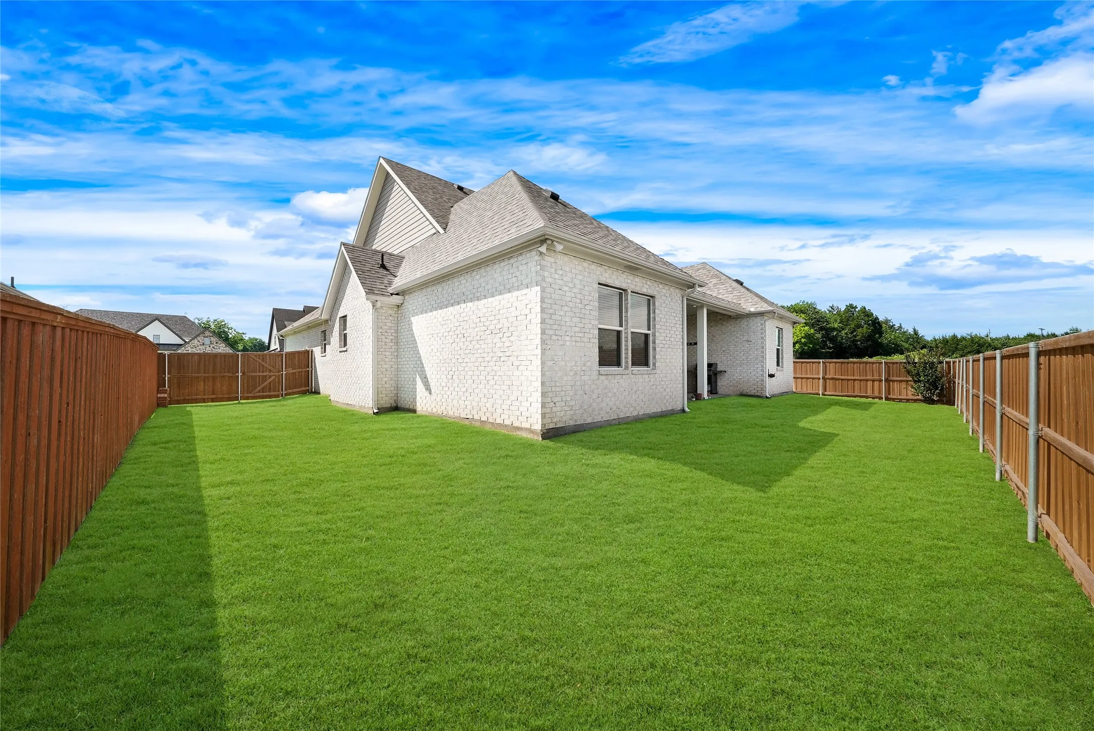 Expansive, fenced backyard featuring a substantial lawn