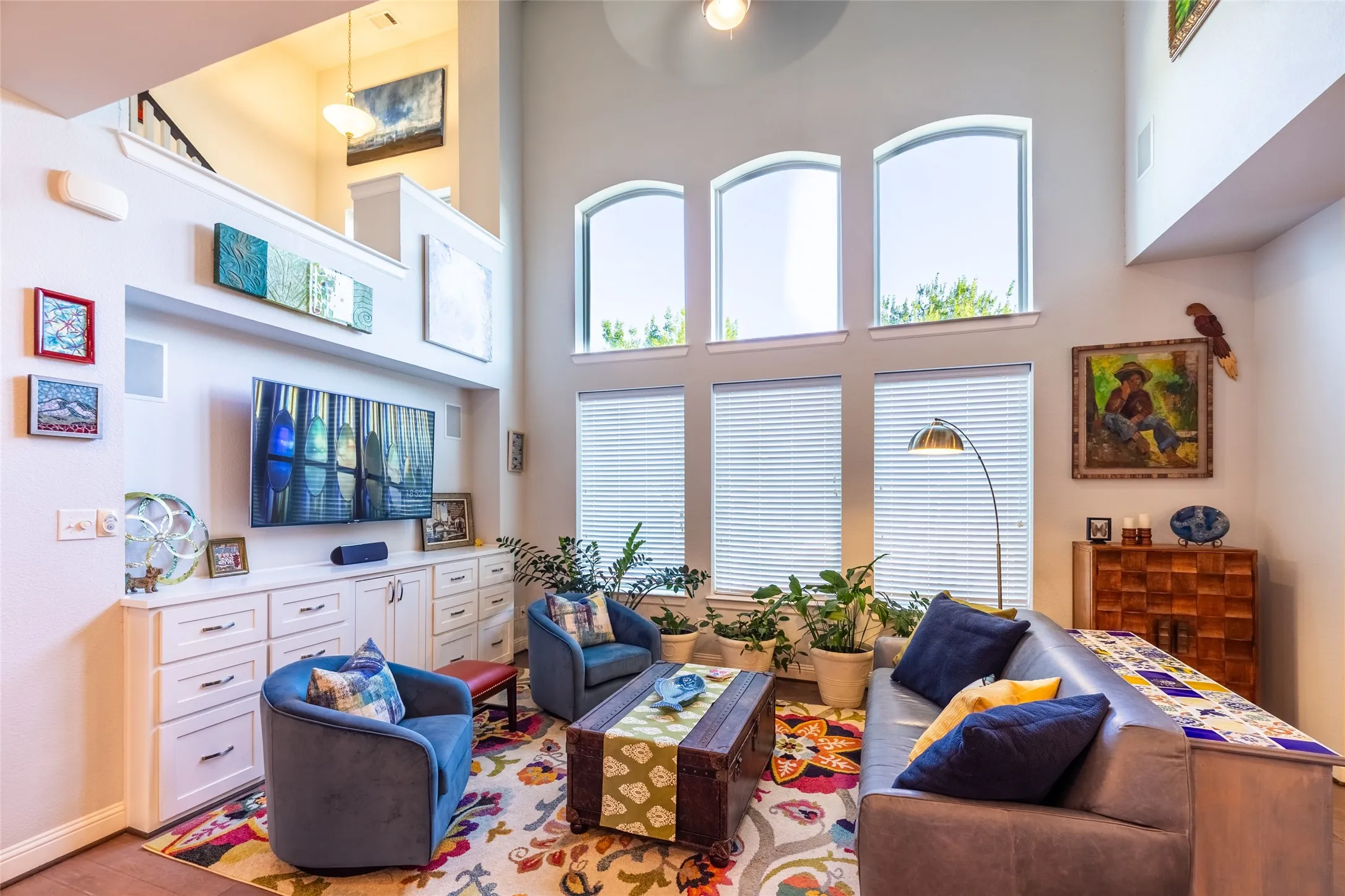 Downstair living room area featuring high arched windows providing abundant natural light