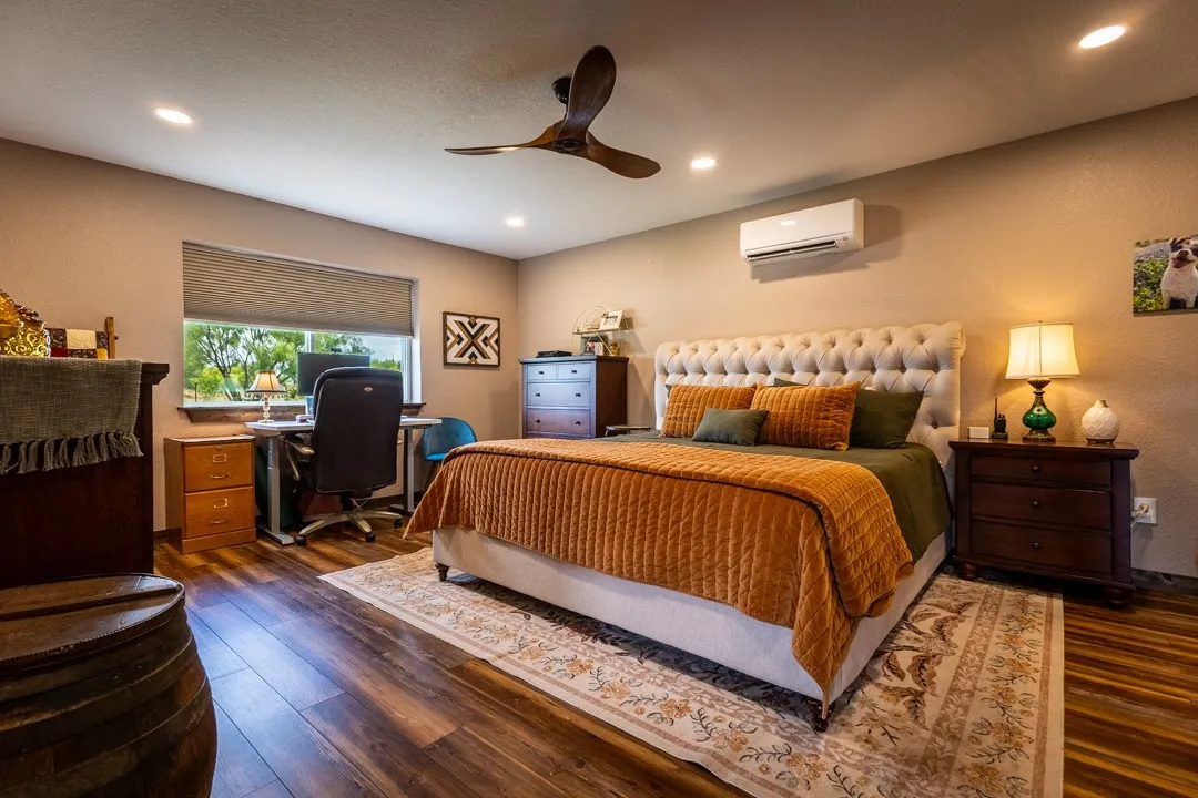 The large bedroom features room for workspace and plenty of natural light, plus an en-suite bath.