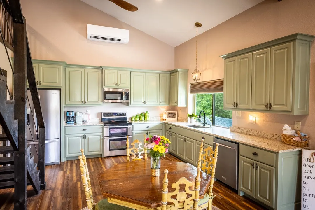 Super efficient, yet roomy kitchen and dining area with a window view towards the lake; stairway leads to the loft.