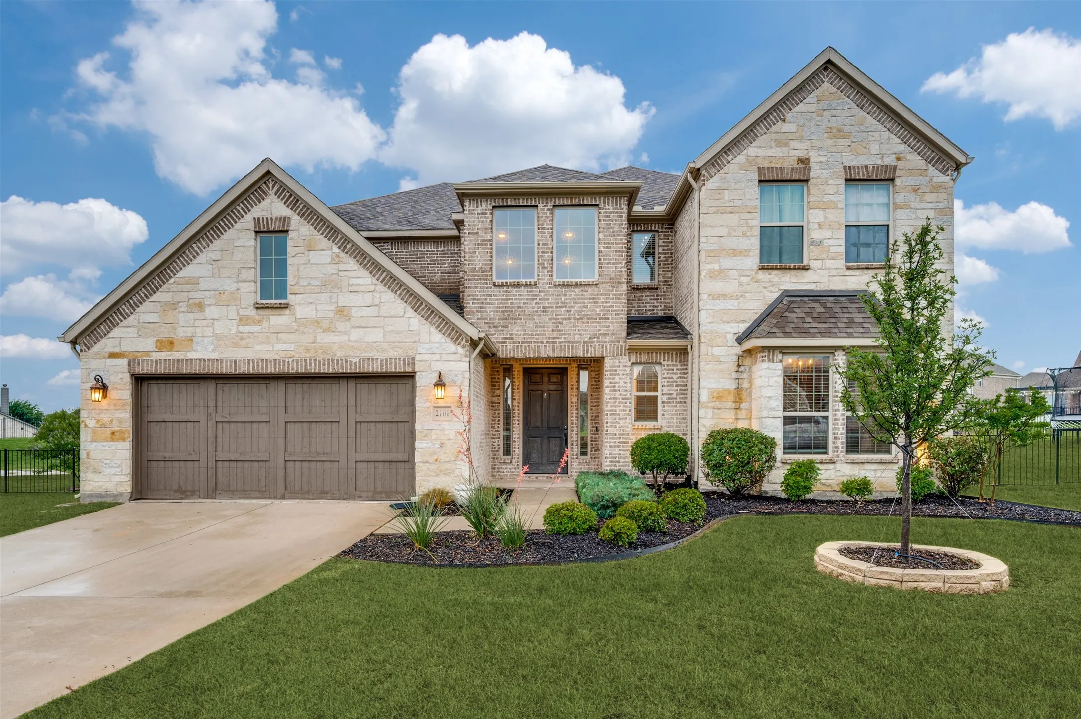 Two-story residence featuring a combination of brick and stone masonry