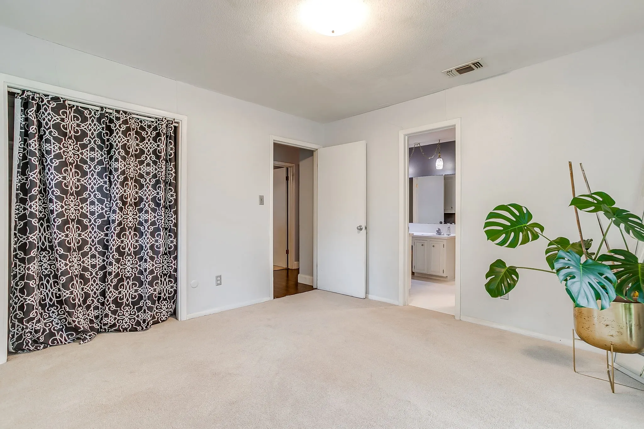 Spacious room featuring light-colored carpeting and white wall finishes