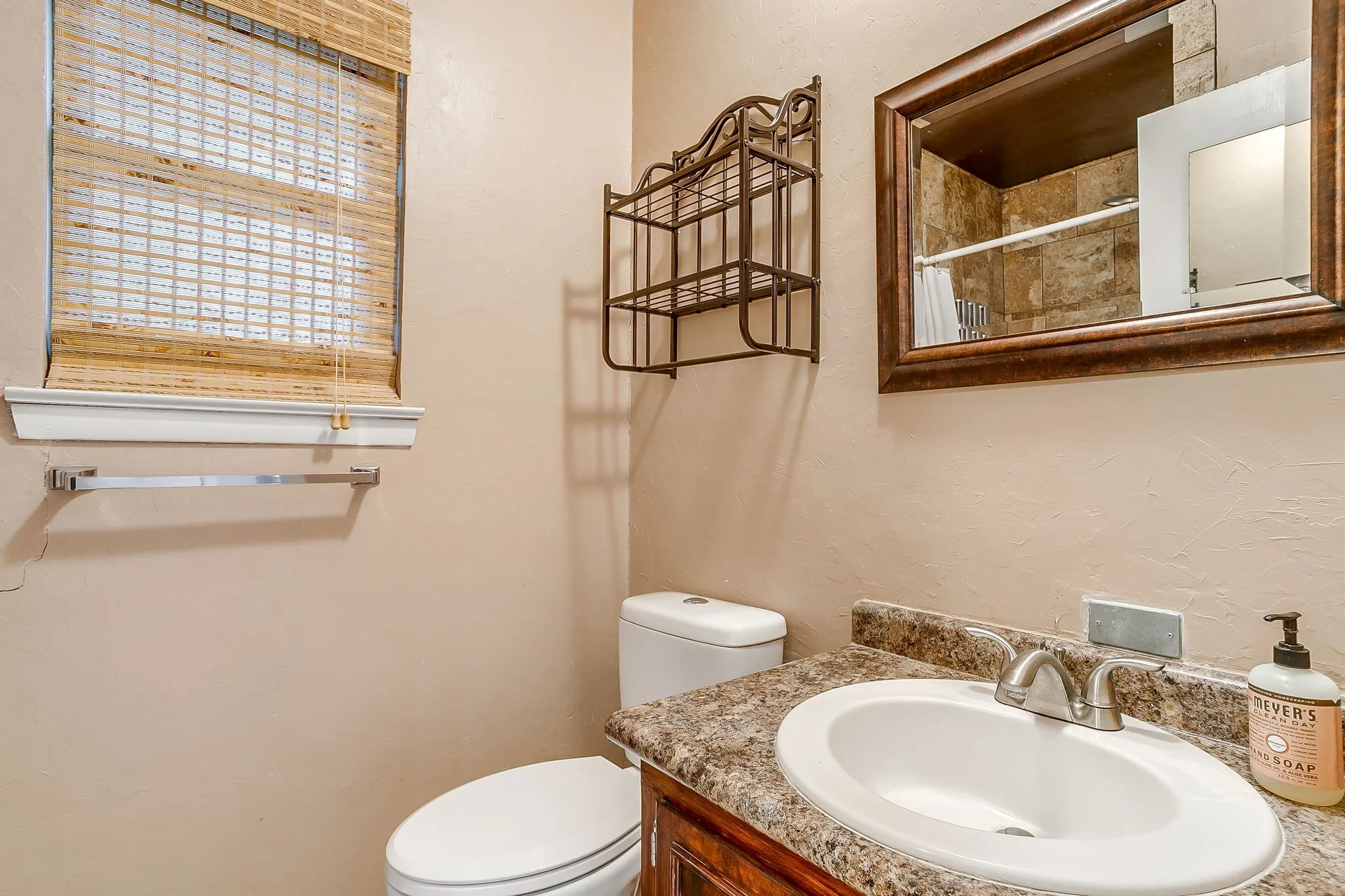 Bathroom vanity with an integrated sink, laminate countertop, and wood-finish cabinetry