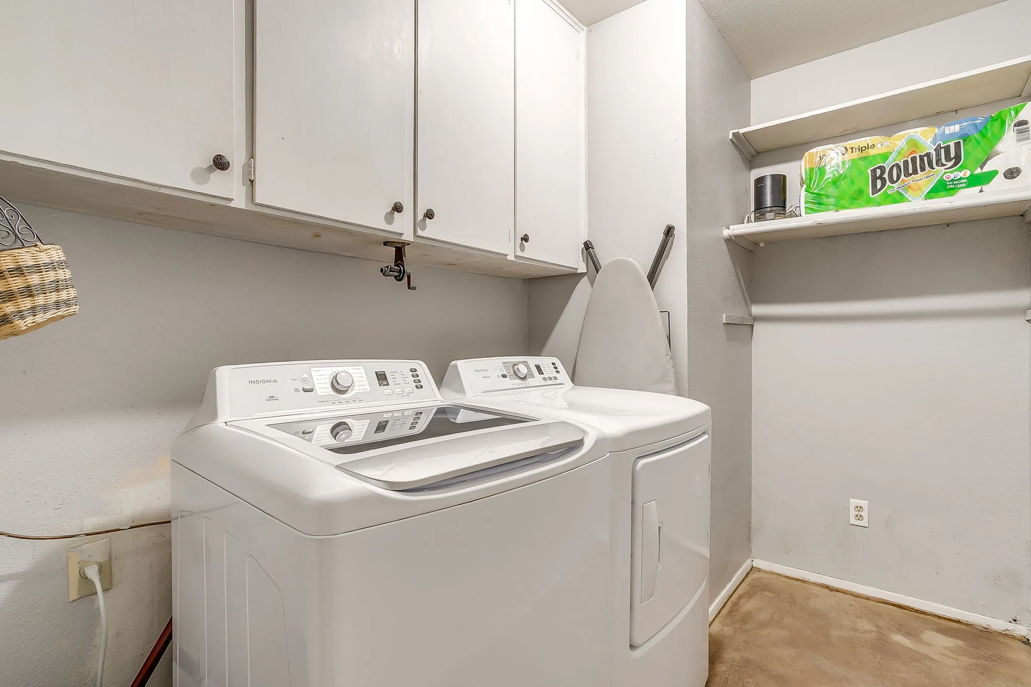 Dedicated laundry area featuring upper white cabinetry, a built-in shelving unit, and a clothing rod