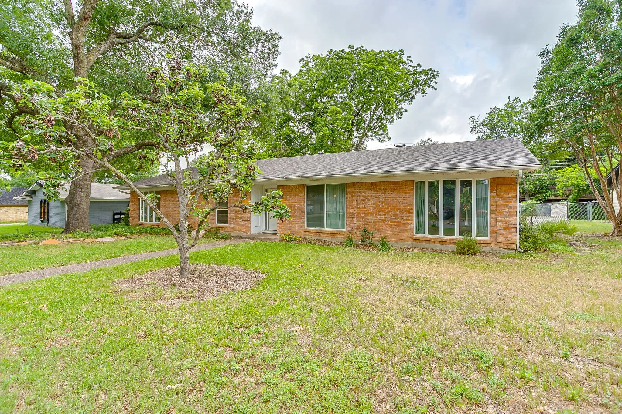Single-story brick exterior home with a light gray shingle roof