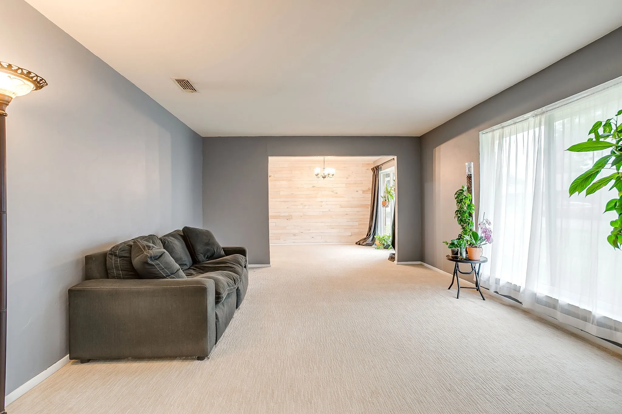 Spacious room featuring light-colored carpeting and cool-toned wall paint