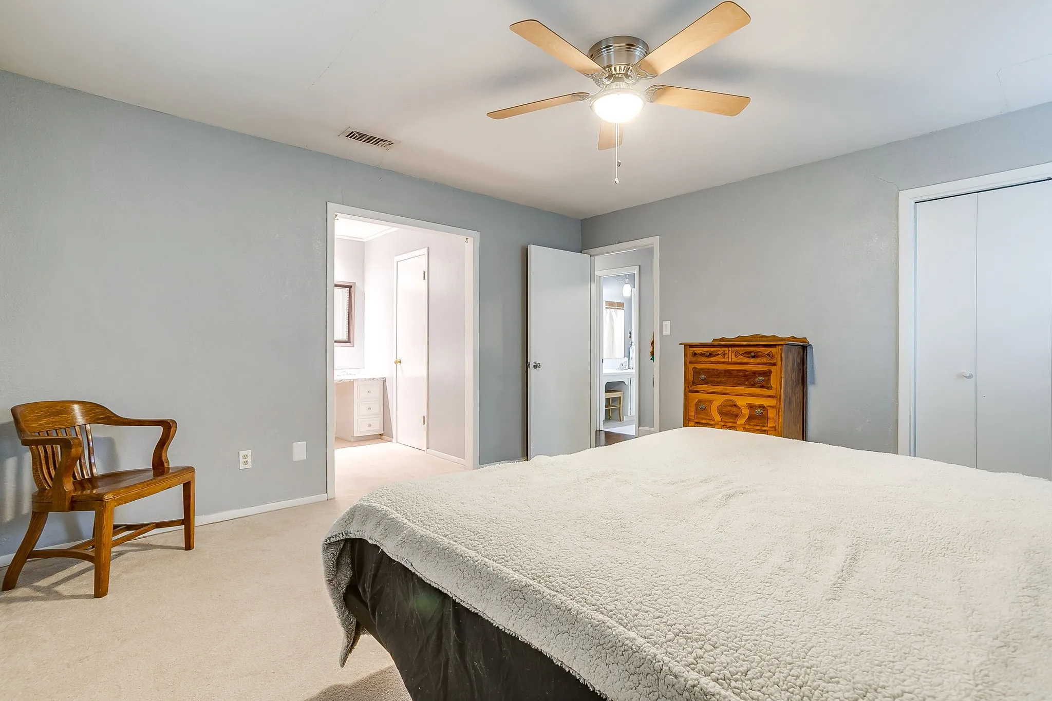 Carpeted room featuring a ceiling fan with light, light blue wall paint, and white trim