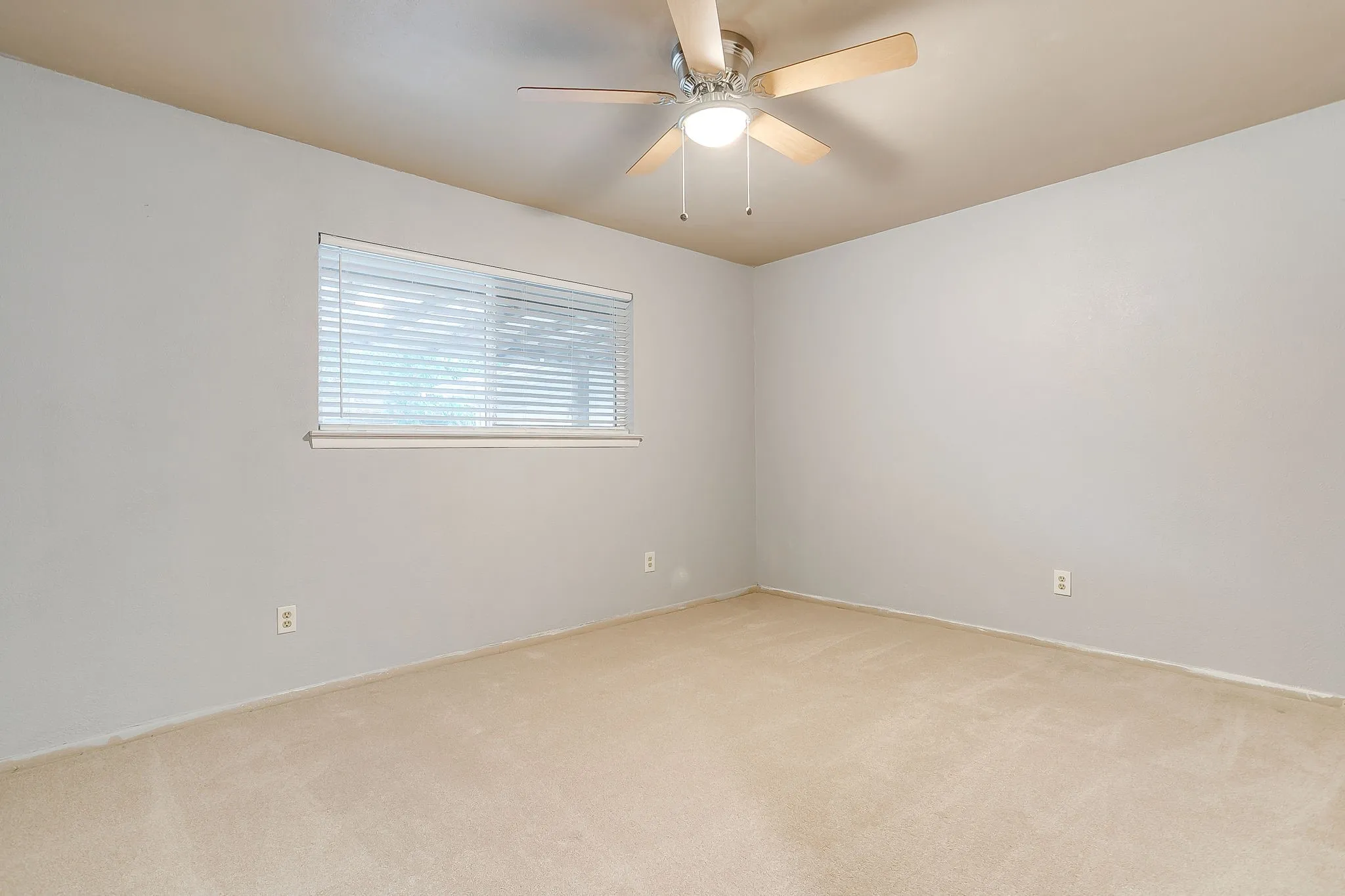 Room featuring light-colored walls and tan carpeting