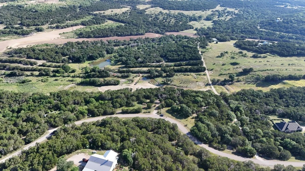 Expansive rural landscape featuring a winding road and verdant tree coverage