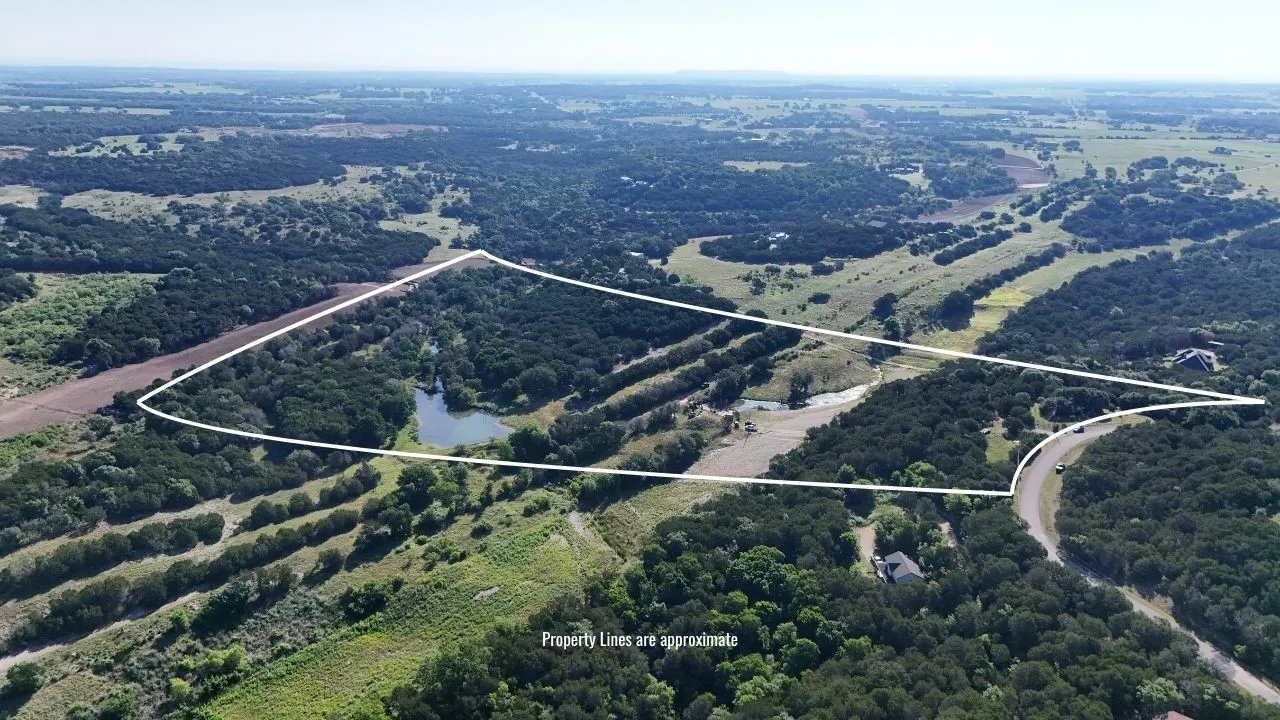Expansive acreage featuring abundant mature trees, a natural pond, and varied topography