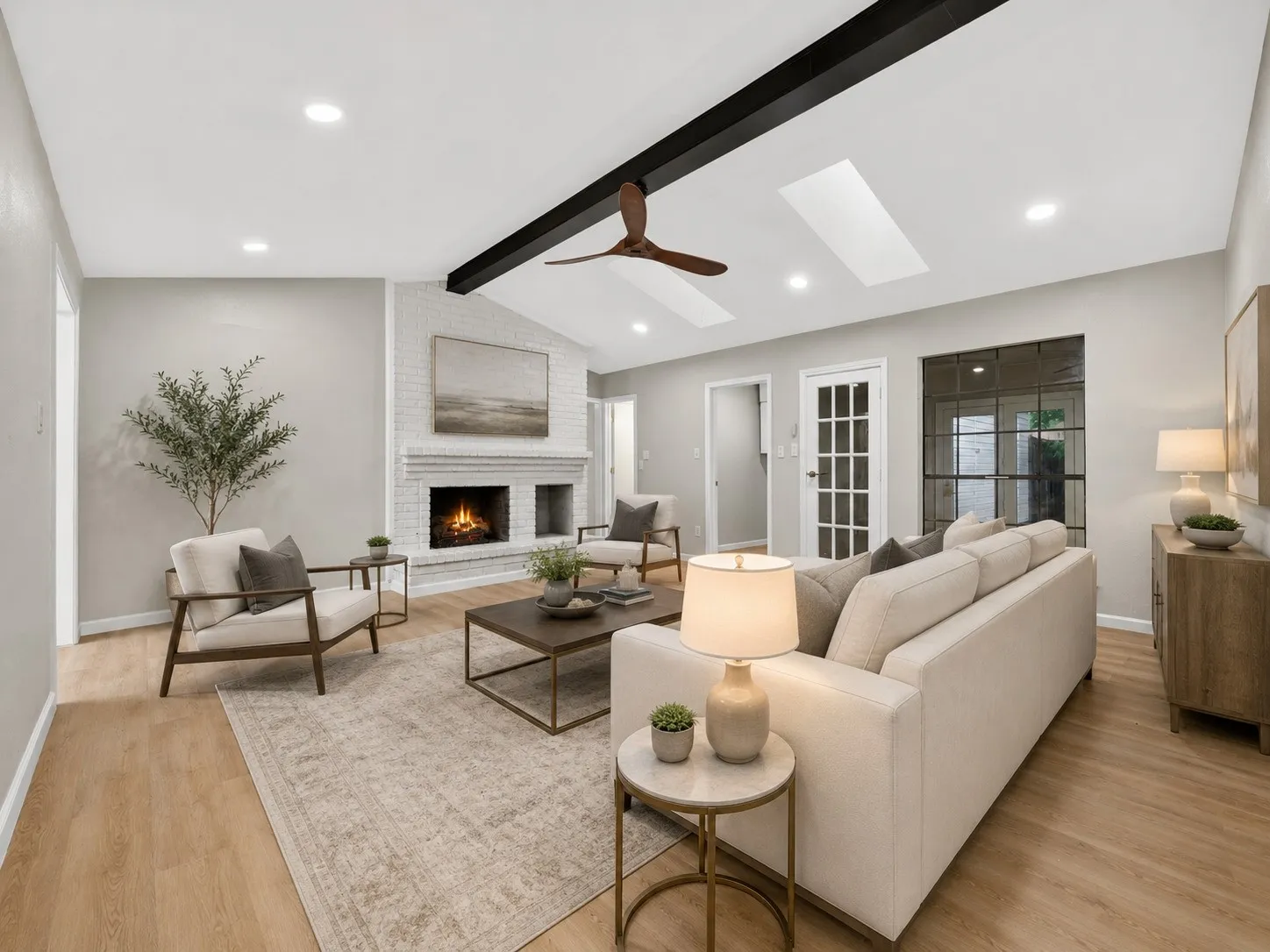 AI staging: Spacious living area featuring a vaulted ceiling with exposed beam, recessed lighting, and skylights