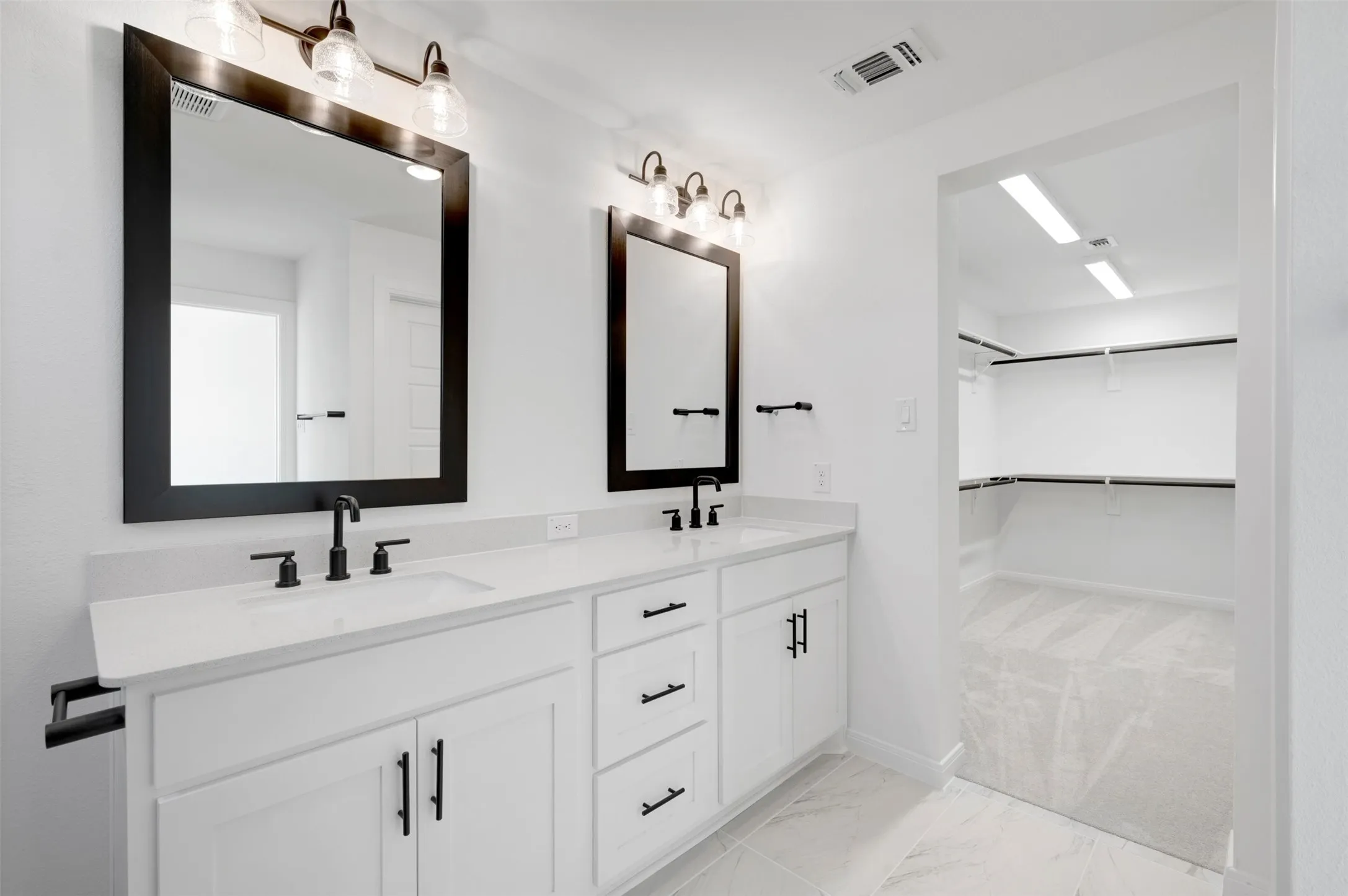 Dual vanity with white cabinetry, matte black hardware, and integrated sinks