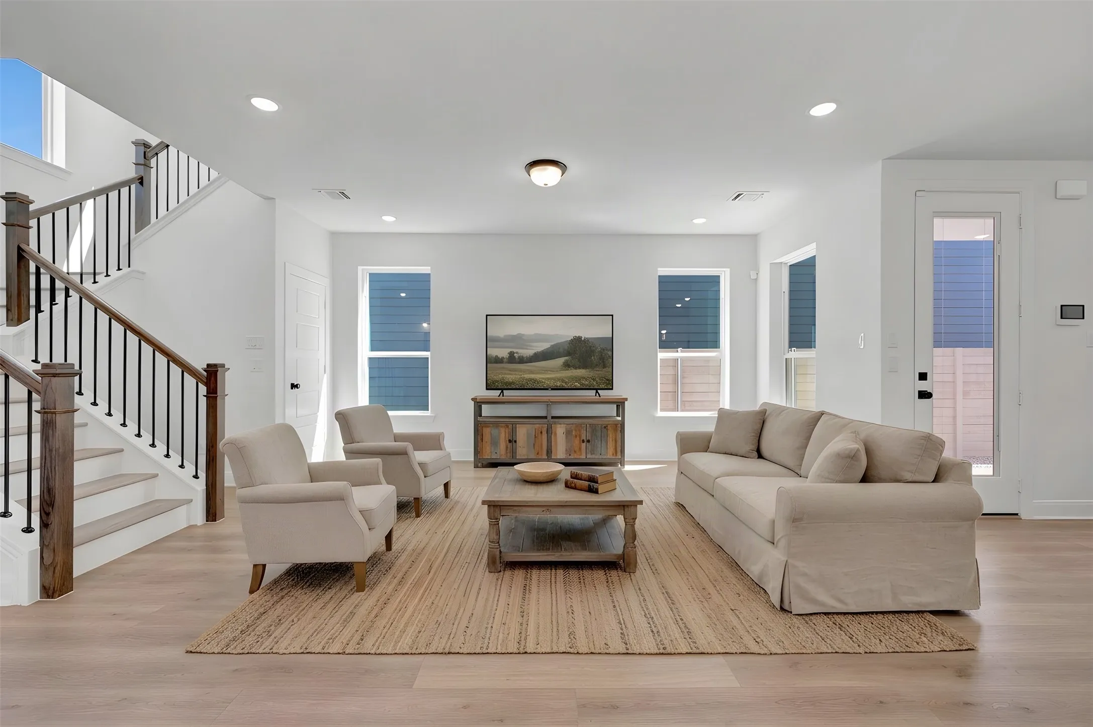Light wood-finish flooring with white walls and recessed lighting