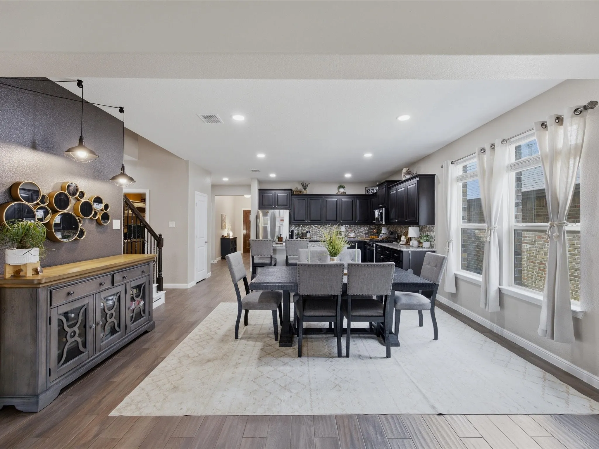 Open-concept interior featuring wood-finish flooring, recessed lighting, and multiple windows