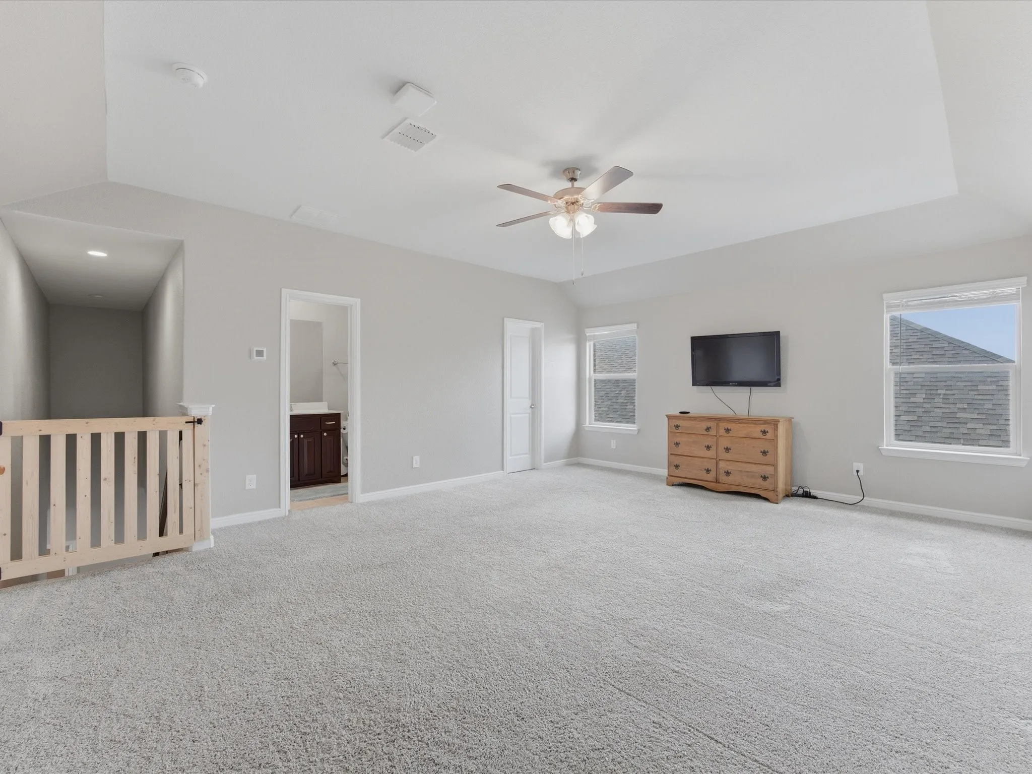 2nd floor bonus room featuring a tray ceiling, ceiling fan with light fixture, light gray walls, and carpeting & full bathroom.