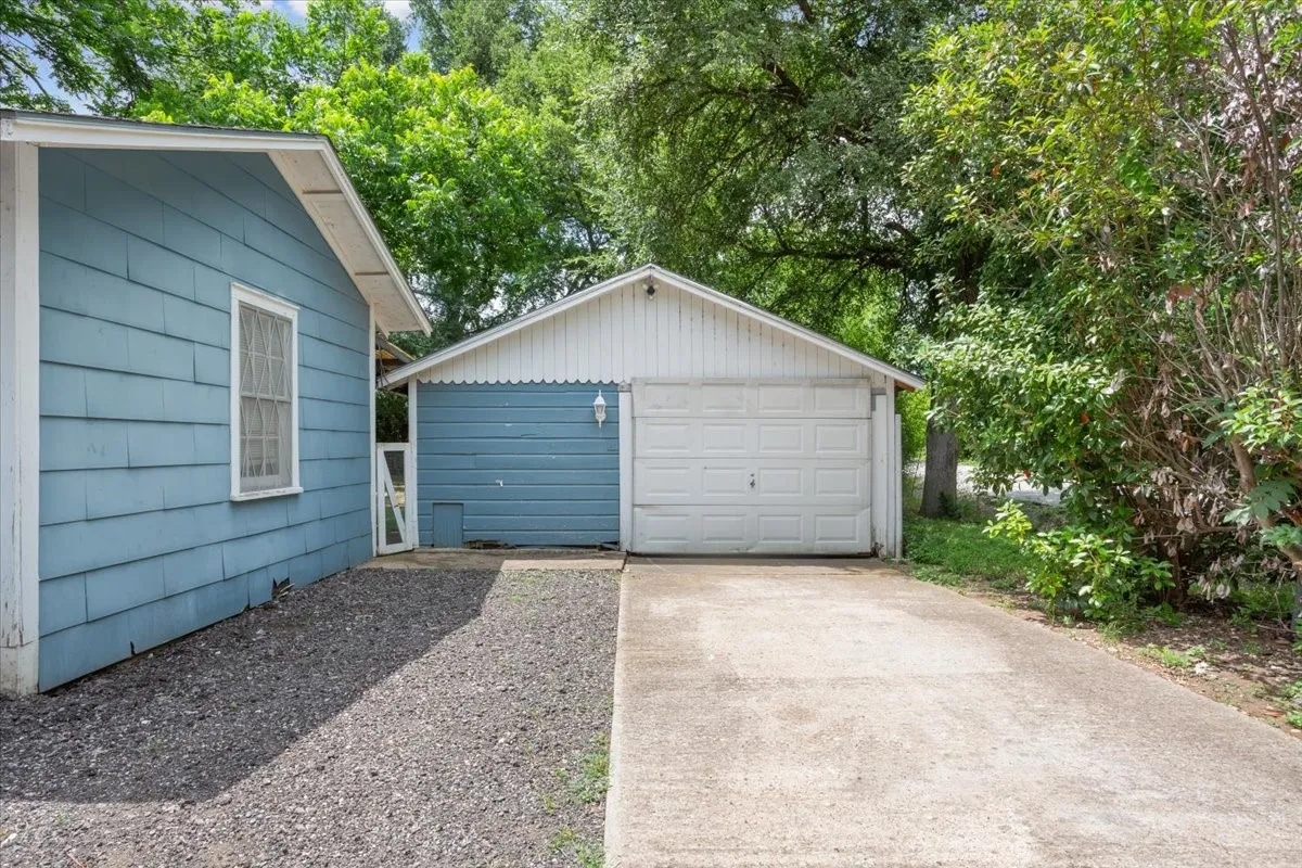Detached garage with a white overhead door and a concrete driveway