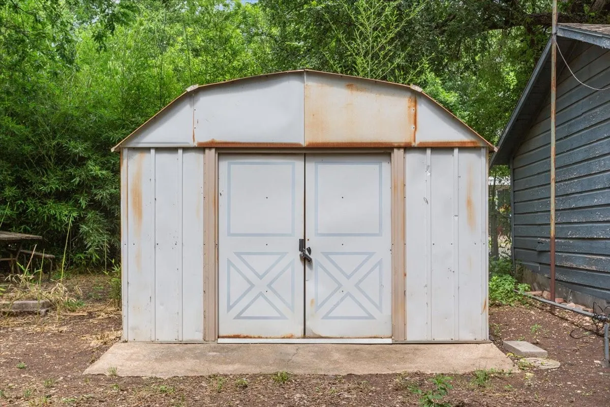 Metal utility shed with double doors and a concrete pad foundation
