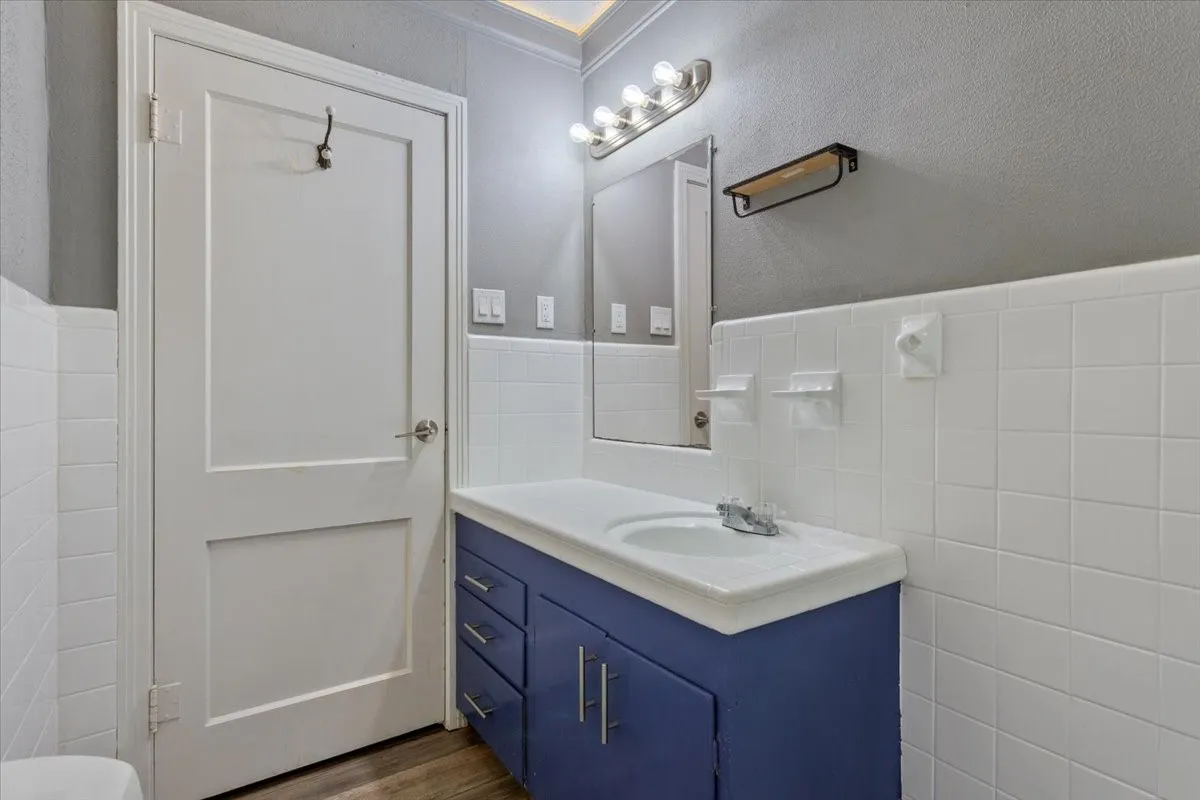 Bathroom vanity featuring a single basin, brushed nickel faucet, and a vibrant blue cabinet with silver hardware