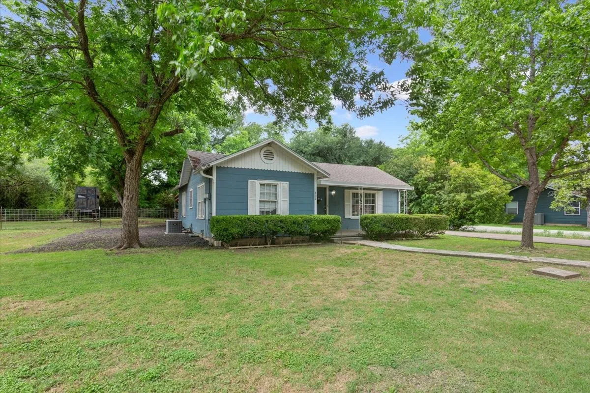 Residential structure featuring a light blue exterior, white trim, and white shutters