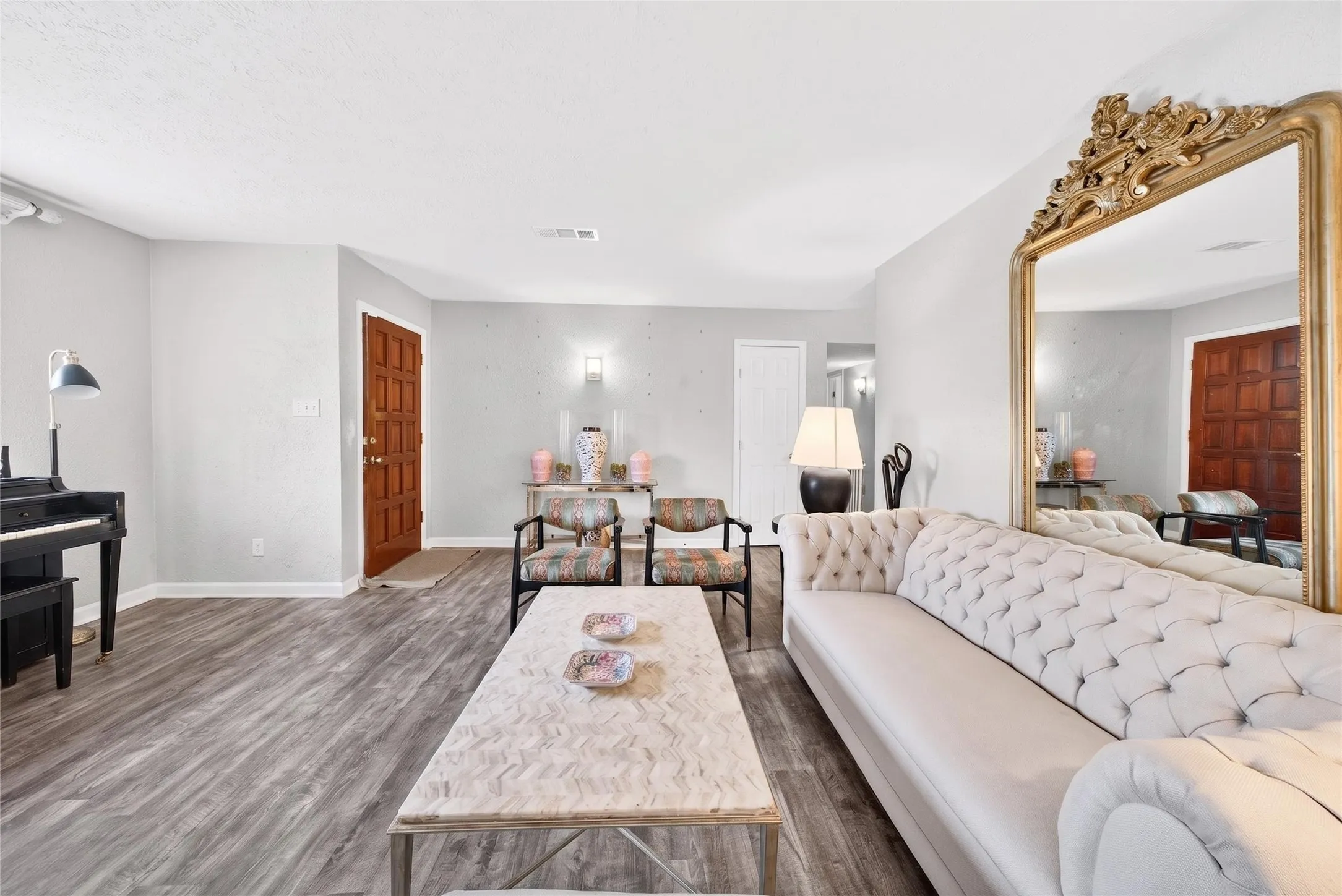 Spacious living area featuring wood-finish flooring and light gray walls