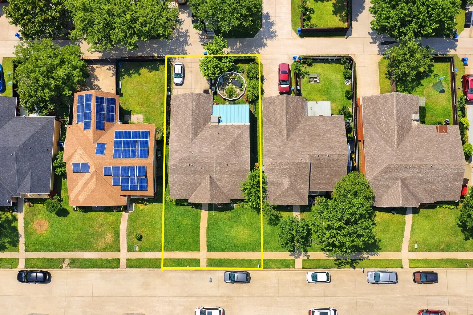 Aerial view of a residential property with a shingle roof and a spacious backyard featuring a pool