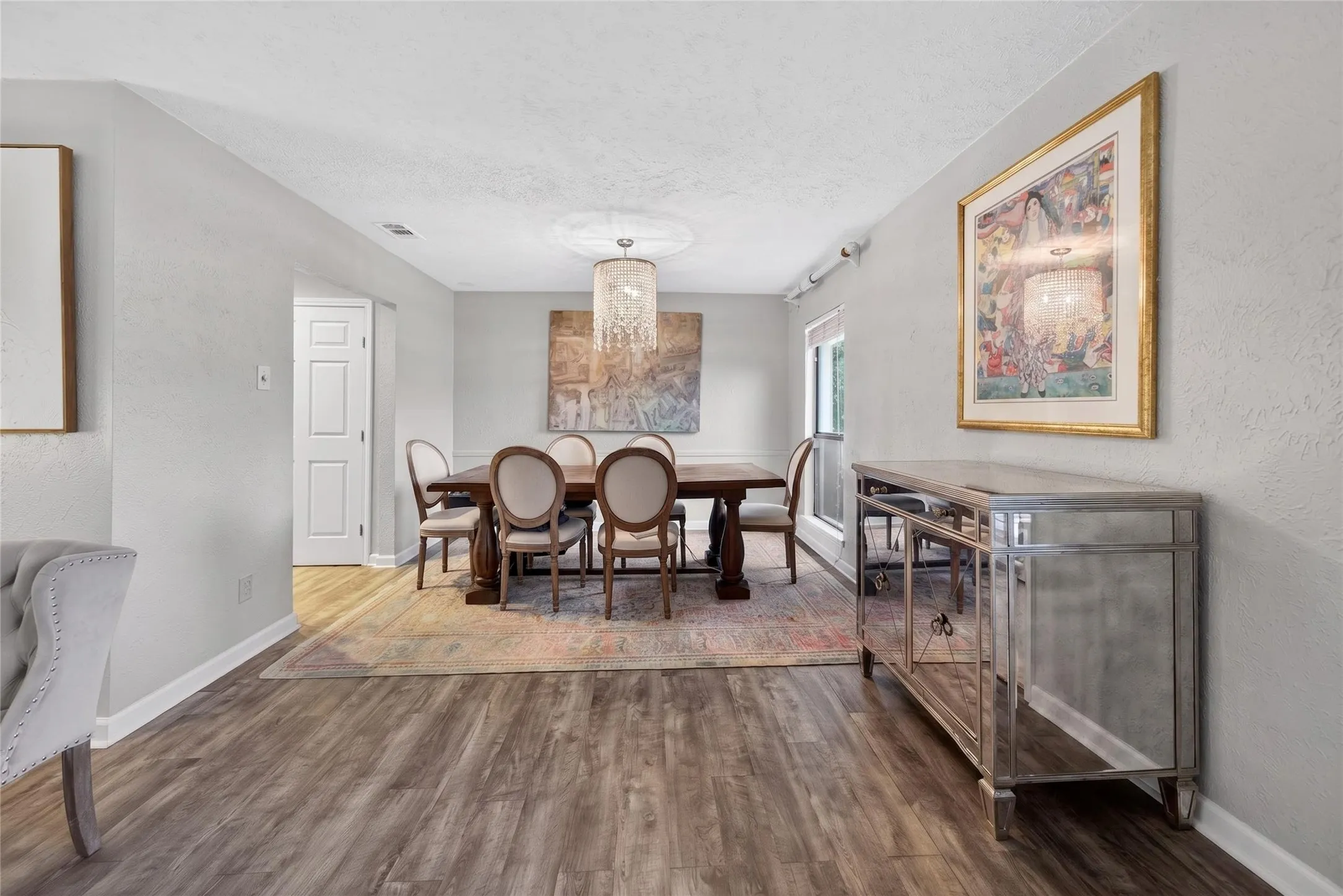 Dining area featuring wood-finish flooring, light gray wall paint, and a crystal chandelier