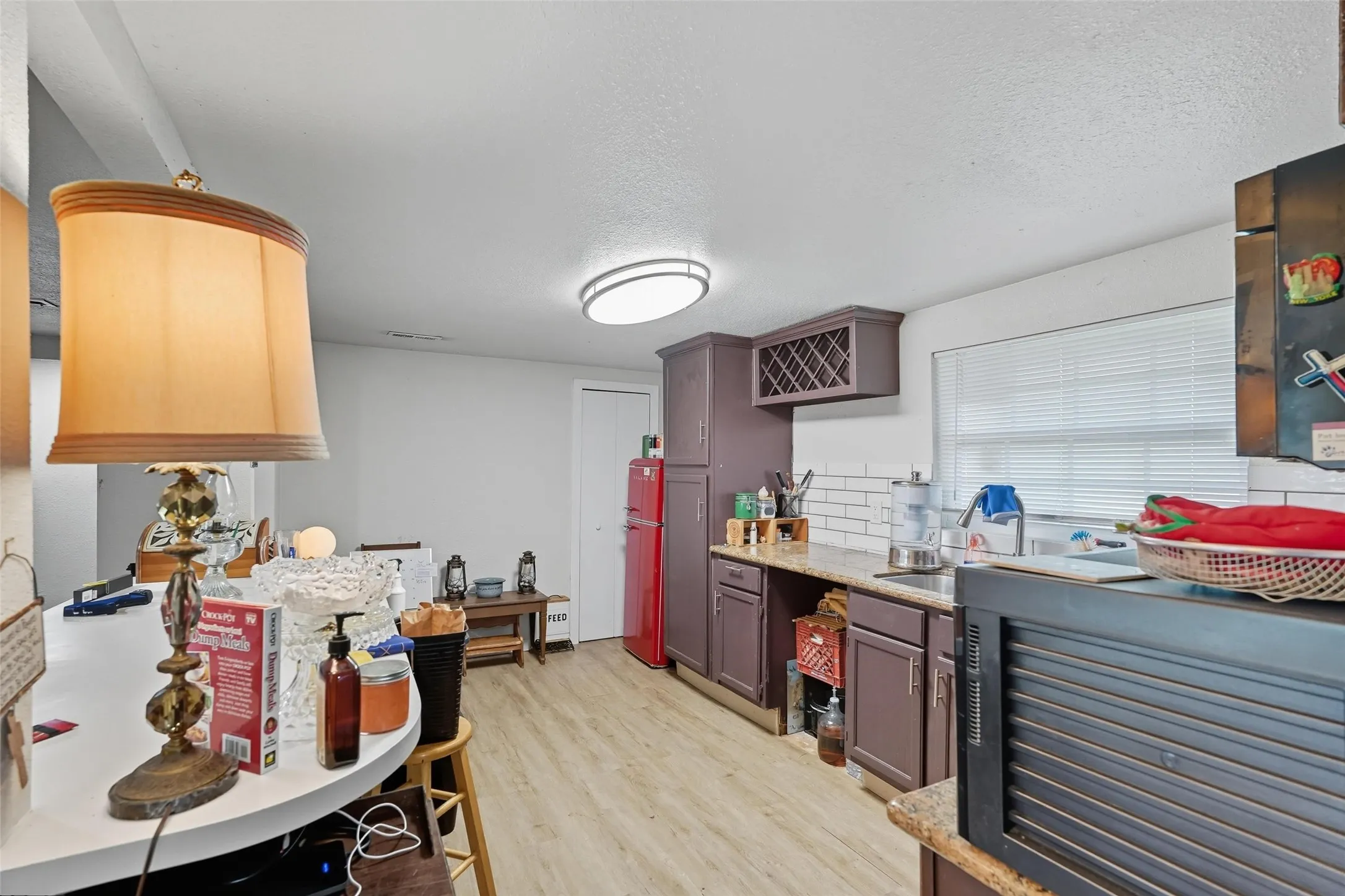 Kitchen area with wood-finish flooring and white walls