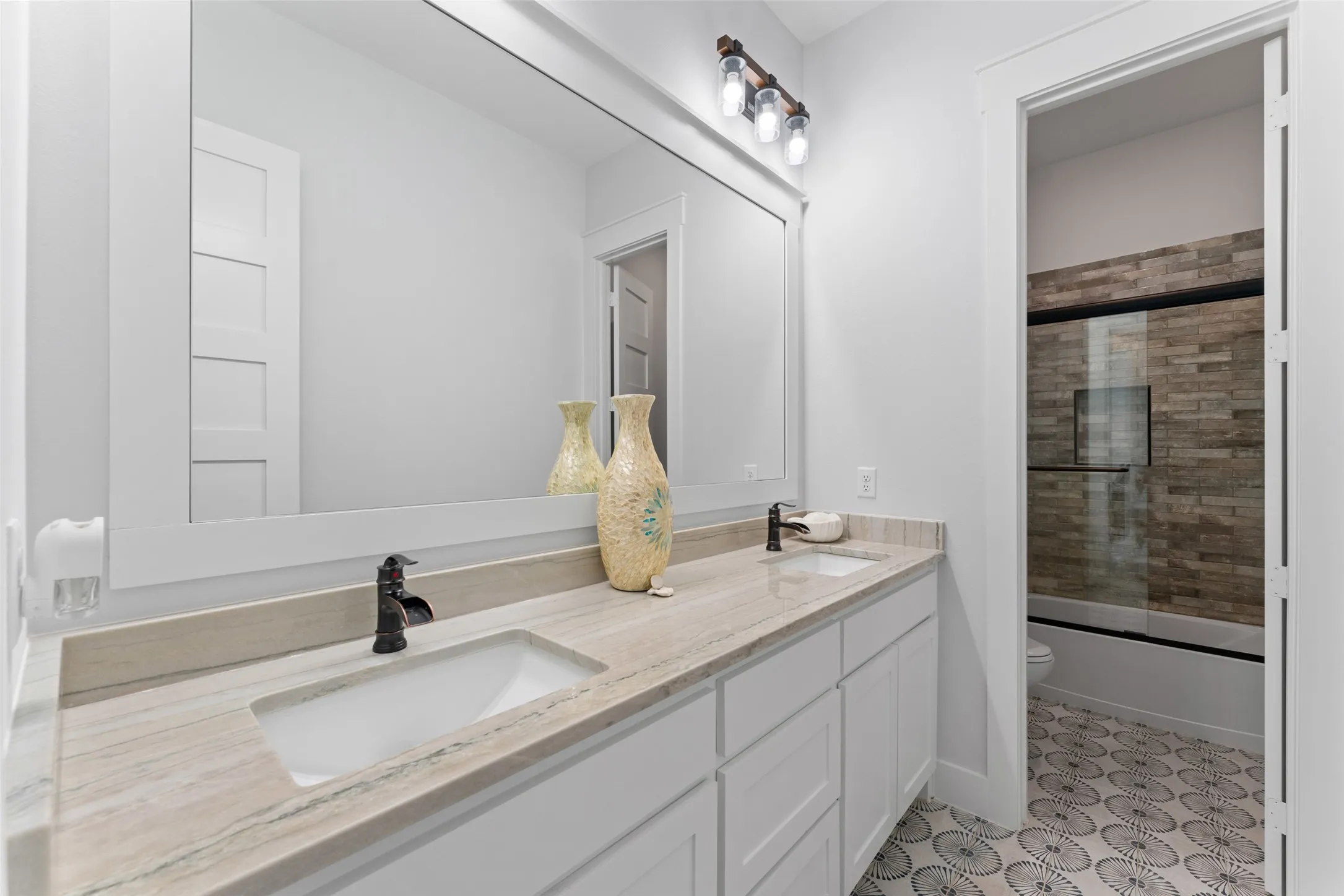 Dual vanity featuring a light-toned countertop, integrated sinks, and dark bronze faucets